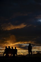 People marvelling at Montafon mountains with dramatic cloudy sky at sunset, Tschagguns, Rätikon,