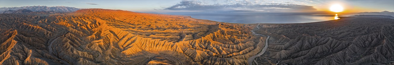 Panorama, river bed runs through a landscape of eroded hills at Lake Issyk Kul, badlands at