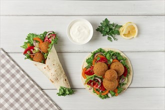 Tortillas, wrapped falafel balls, with fresh vegetables, vegetarian healthy food, on a wooden white