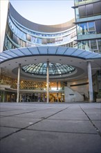 Modern office building with glass façade and curved canopy in the entrance area, City Plaza,