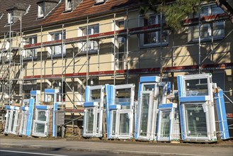 Energy-efficient refurbishment of residential buildings, older apartment block is scaffolded, gets