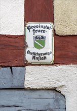 Old sign of the Provinzial Feuerversicherung Anstalt, on a half-timbered building, Monreal, idyllic