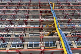 Large construction site, scaffolded shell of an office building complex, air hoses for building