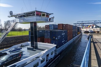 Container cargo ship enters the port basin of the Logport, gantry cranes in the Container Handling