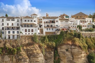 Famous Ronda restaurants and colonial houses overlooking the scenic gorge and the Puente Nuevo