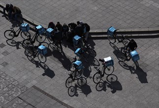 Bicycles and drivers of the food delivery service WOLT at their meeting point, Hauptwache, view