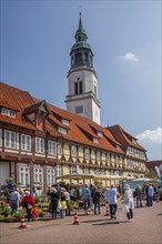 Weekly market with typical half-timbered houses in the old town centre and the tower of the town