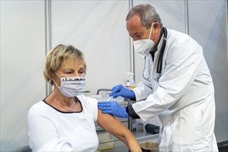 Vaccinator administers a vaccination, during the test run in the vaccination centre for corona