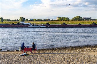 The Rhine at Duisburg-Baerl, man and woman having a picnic on the Rhine beach, at low tide, on the