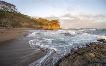 Sandy beach beach with rocks and sea at sunset, Playa Cocalito, coastal landscape, Pacific coast,