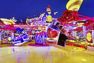 People in the illuminated carousel Circus Circus in the evening, Cranger Kirmes, Herne, Ruhr area,