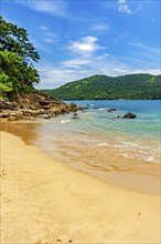 Remote and paradisiacal beach in Trindade, municipality of Paraty, surrounded by hills and tropical