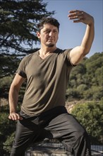 Vertical portrait from a low angle of a middle-aged Caucasian man training alone in martial arts.