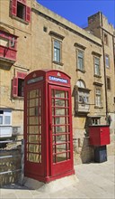 Red telephone box booth in historic city centre of Valletta, Malta, Europe