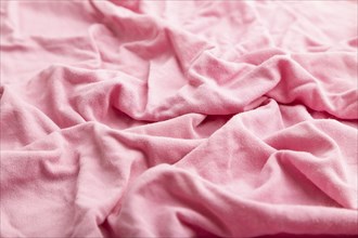 Fragment of pink cotton tissue. Side view, natural textile background and texture. wave concept,