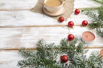 Christmas or New Year composition. Decorations, red balls, fir and spruce branches, cup of coffee,