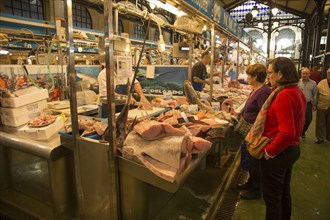 People shopping at fishmonger stalls inside historic covered market building, Jerez de la Frontera,