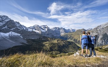 Two mountaineers, on a hiking trail, friendship on the mountain, mountain panorama with rocky steep