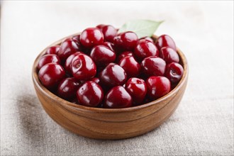 Fresh red sweet cherry in wooden bowl on wooden background. side view, close up