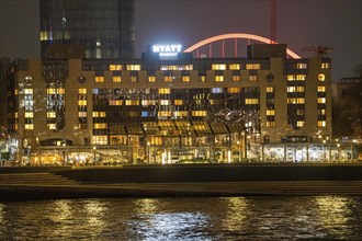 The Hyatt Regency Hotel on the Rhine, in Cologne Deutz, behind it the illuminated arch of the