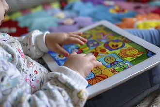 Close up of young toddler child's hands playing game on computer tablet. Generative Ai, AI