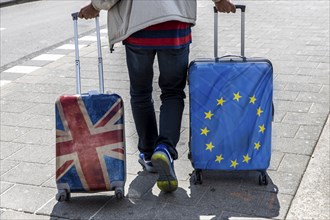 Symbolic image Brexit, man with 2 trolley suitcases, one with Union Jack, and Europe flag design