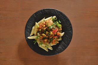 Overhead view of plate with beef slices fried with vegetables and spicy sauce with pasta