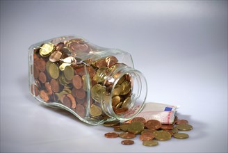 Euro coins in a jar, banknotes