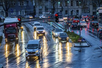 Rainy weather, road traffic, intersection, lights of vehicles on a wet road, traffic lights, tail