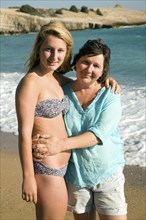 Model released mother and daughter embrace on holiday at the beach, Rhodes, Greece, Europe