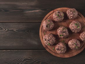 Raw meatballs, with micro greenery, on a cutting board, homemade, rustic, no people