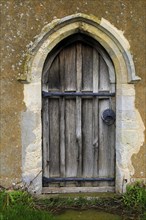 Small doorway wooden door into Ramsholt church, Suffolk, England, UK