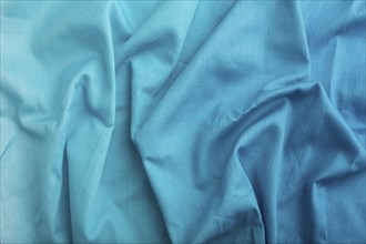 Fragment of cotton blue tissue. Top view, natural textile background and texture. wave concept,