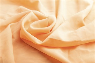 Fragment of orange linen tissue. Side view, natural textile background and texture. wave concept,