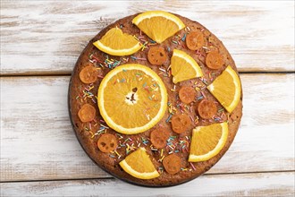 Orange cake on a white wooden background. Top view, flat lay, close up