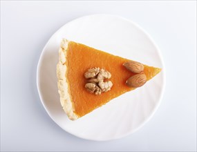 A slice of traditional american sweet pumpkin pie isolated on white background. top view