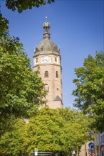 A historic church tower with clock, surrounded by trees and a clear sky, Harz Mountains, Germany,