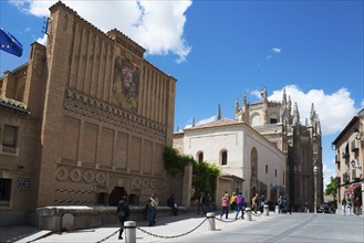 Pedestrian zone in Toledo with historic buildings and a Gothic church under a blue sky, art school,