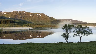 Landscape in the Lofoten Islands. Lake Lilandsvatnet, mountains in the background. Trees in the