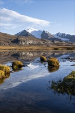 Glaciated mountain peaks reflected in a mountain lake at sunset, Arabel Lake at Arabel Pass, Issyk