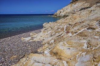 Coastal scene with rocks and blue water under a clear sky, Lambi beach, pebble beach, Patmos,