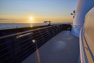 Deck of a ship at sunrise with clear sky and blue railing, Mein Schiff 6, North Sea, Denmark,