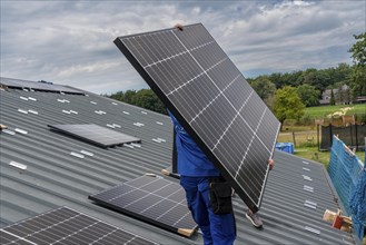 Installation of solar modules on the roof of a barn on a farm, over 240 photovoltaic modules are