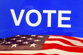 USA flag in front of a blue screen with the inscription VOTE