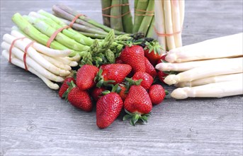 Green asparagus, white asparagus and fresh strawberries decorated on a rustic wooden table