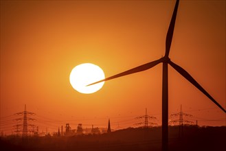 Wind turbine of the Emschergenossenschaft, view to the west, in Essen, sunset, behind the blast