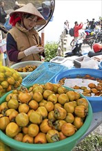 Vietnamese woman peeling khaki fruit at Heavens Gate, Ha Giang province, Vietnam, Asia