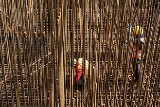 Construction site, reinforced concrete construction site, workers erect a mesh of reinforcing bars,