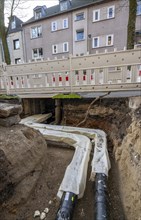 Construction site of a district heating house connection, pipes, insulated, are laid from a central