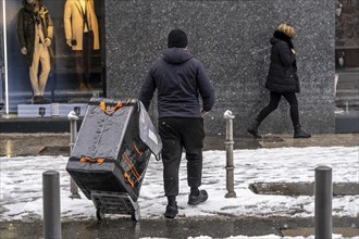 Winter in Frankfurt, Amazon delivery employee brings a shipment to the customer, on foot, in the